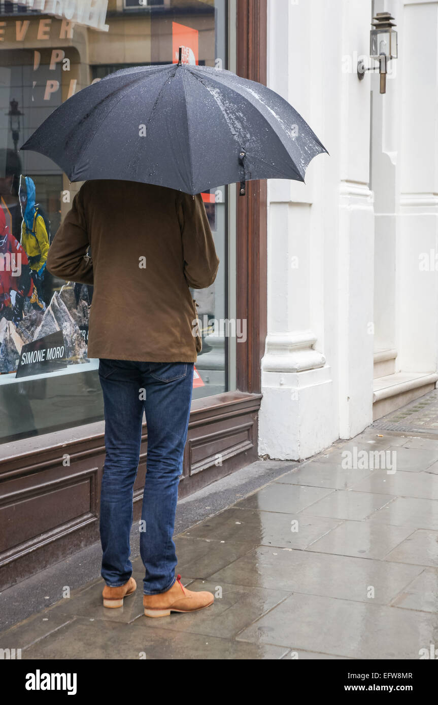 Mann mit Regenschirm, London England Vereinigtes Königreich UK Stockfoto