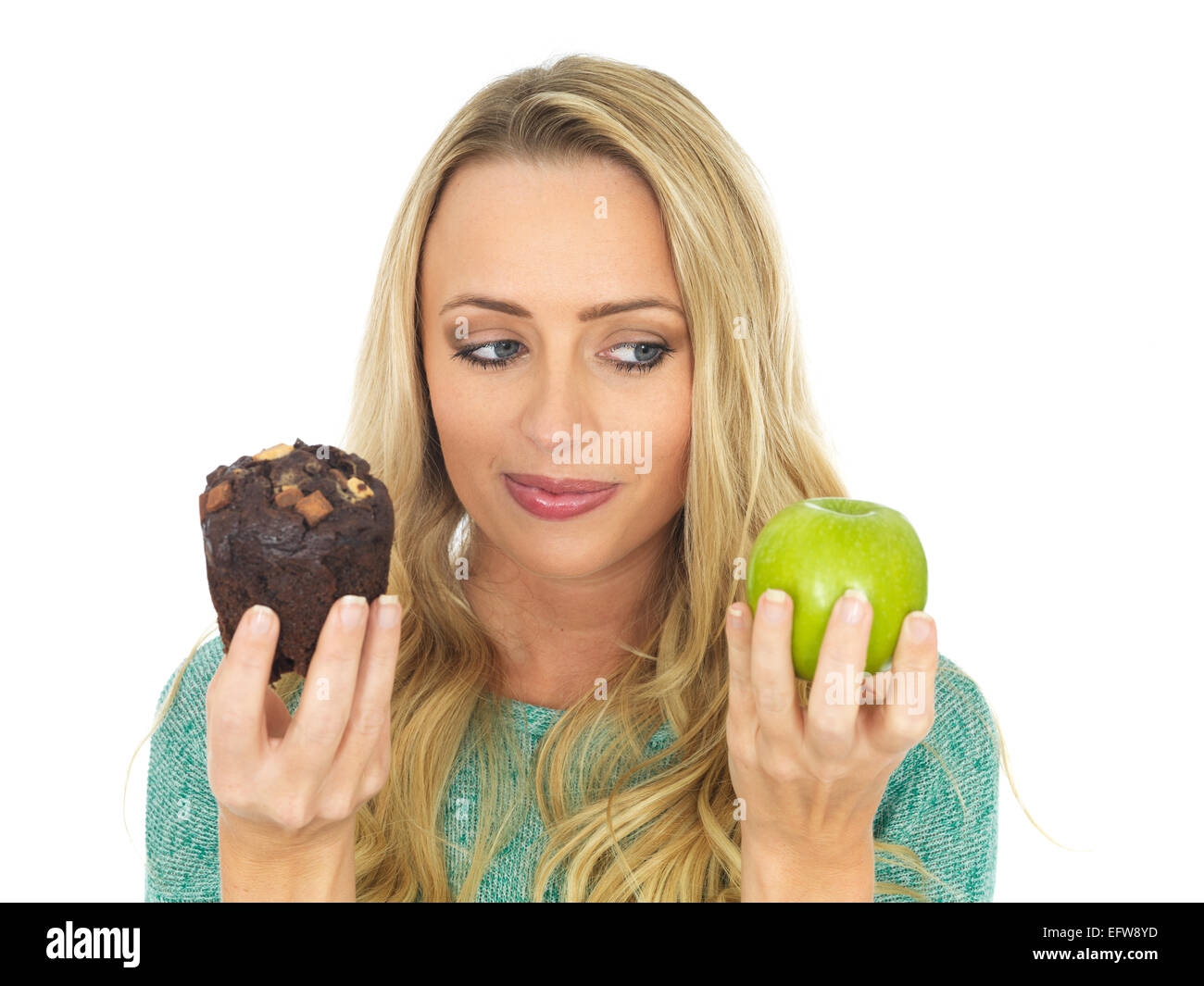 Junge Frau mit und Vergleichen von Kuchen und Obst Stockfoto