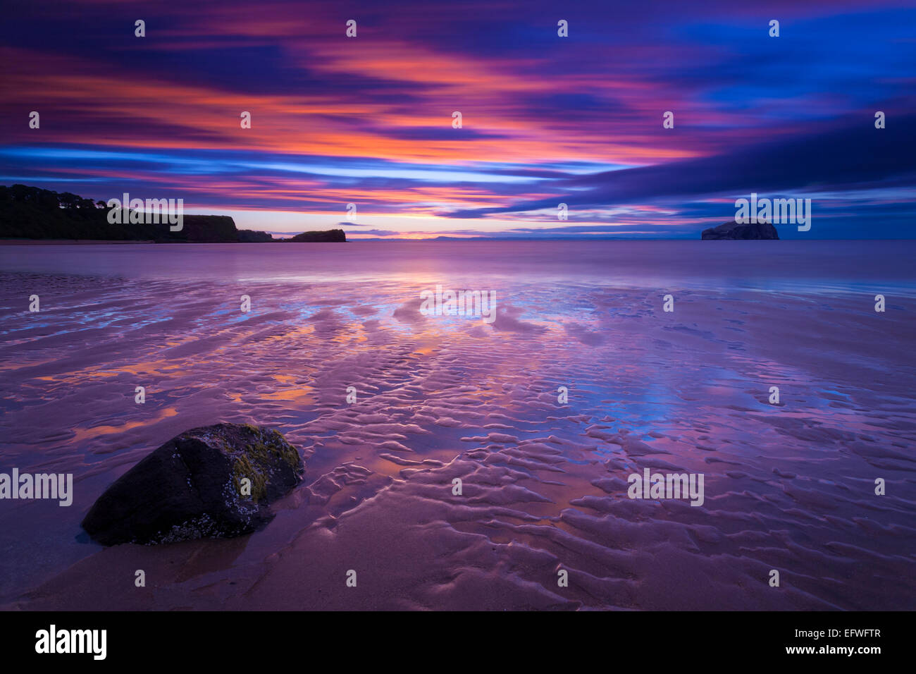 Als die Flut ausging, bildete dieser Felsen und der gewellte Sand einen großen Vordergrund, mit dem Bass Rock am Horizont, Seacliff Ebach, East Lothian Stockfoto