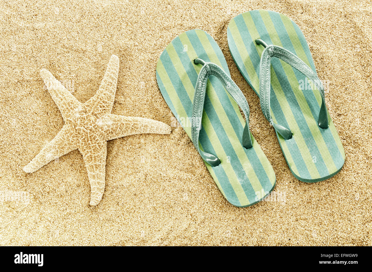 Flip Flops Strand Pantoffeln auf Sandstrand Seestern Sommer Urlaub Urlaub Konzept Kopie Raum Digital Filter verblasst retro vintage Stockfoto