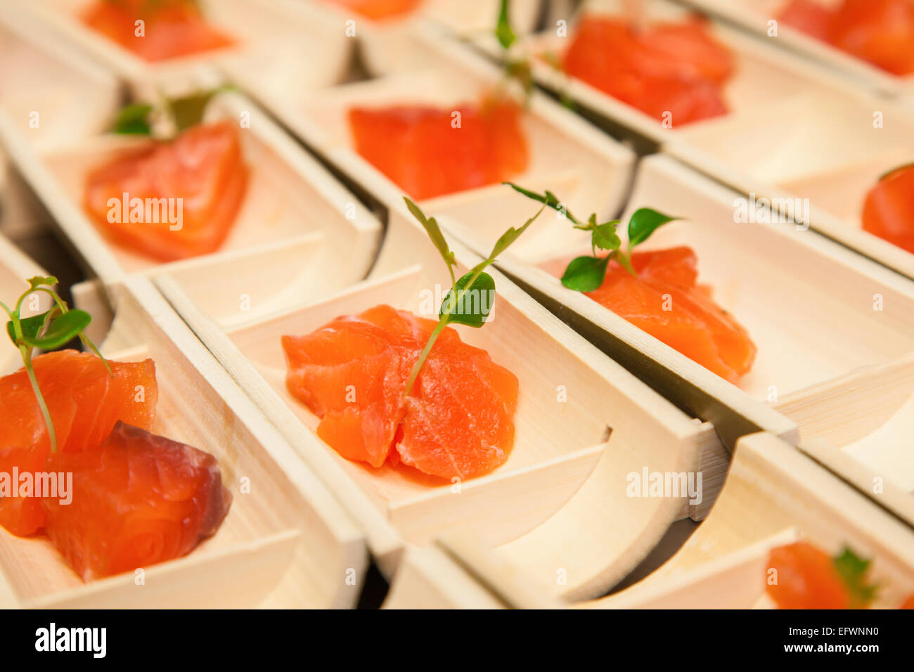 Roher Lachs Sushi Fleischwürfel auf schwarzem Hintergrund. Stockfoto