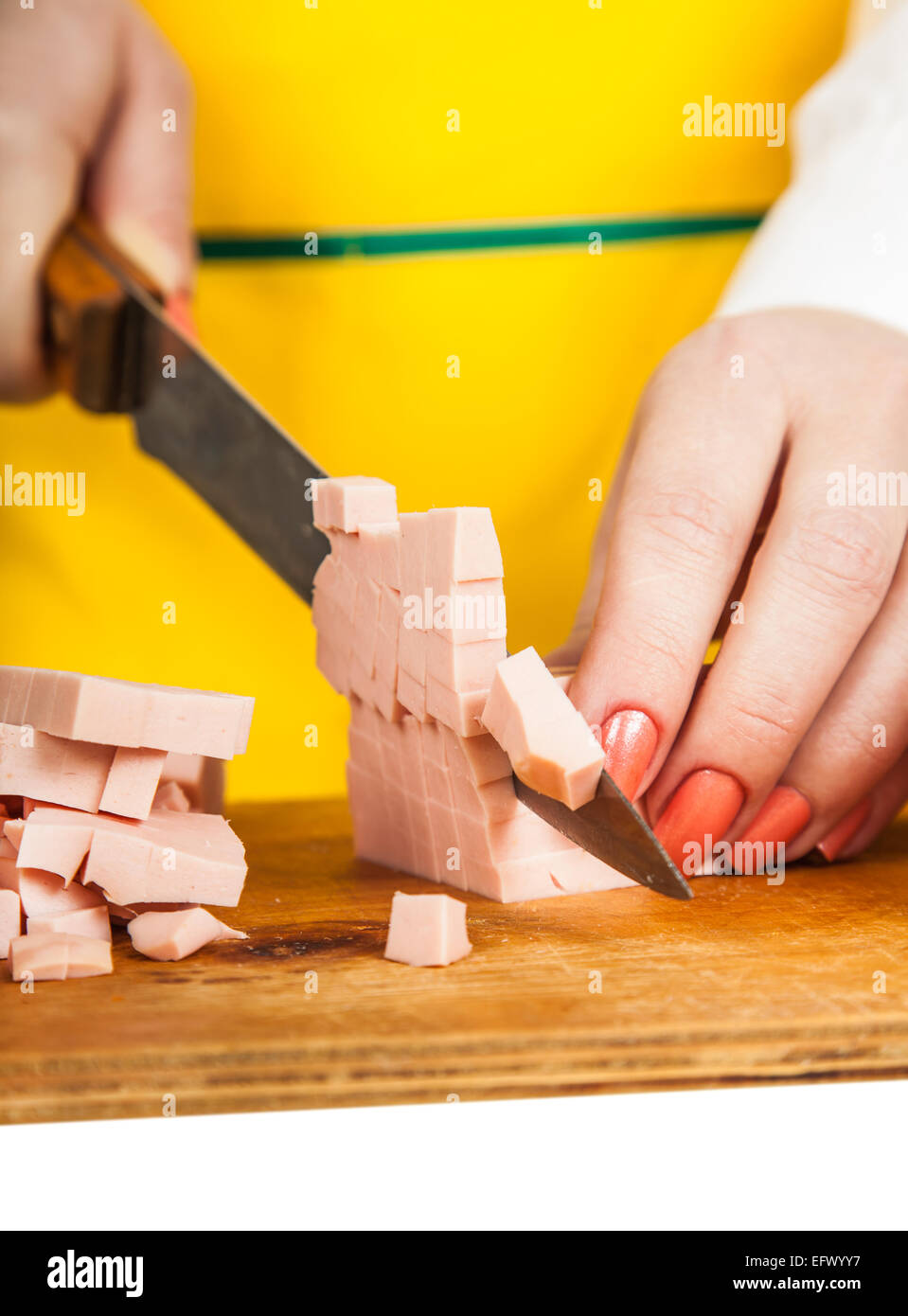 weibliche Hände Closeup Wurst in Würfel schneiden Stockfoto