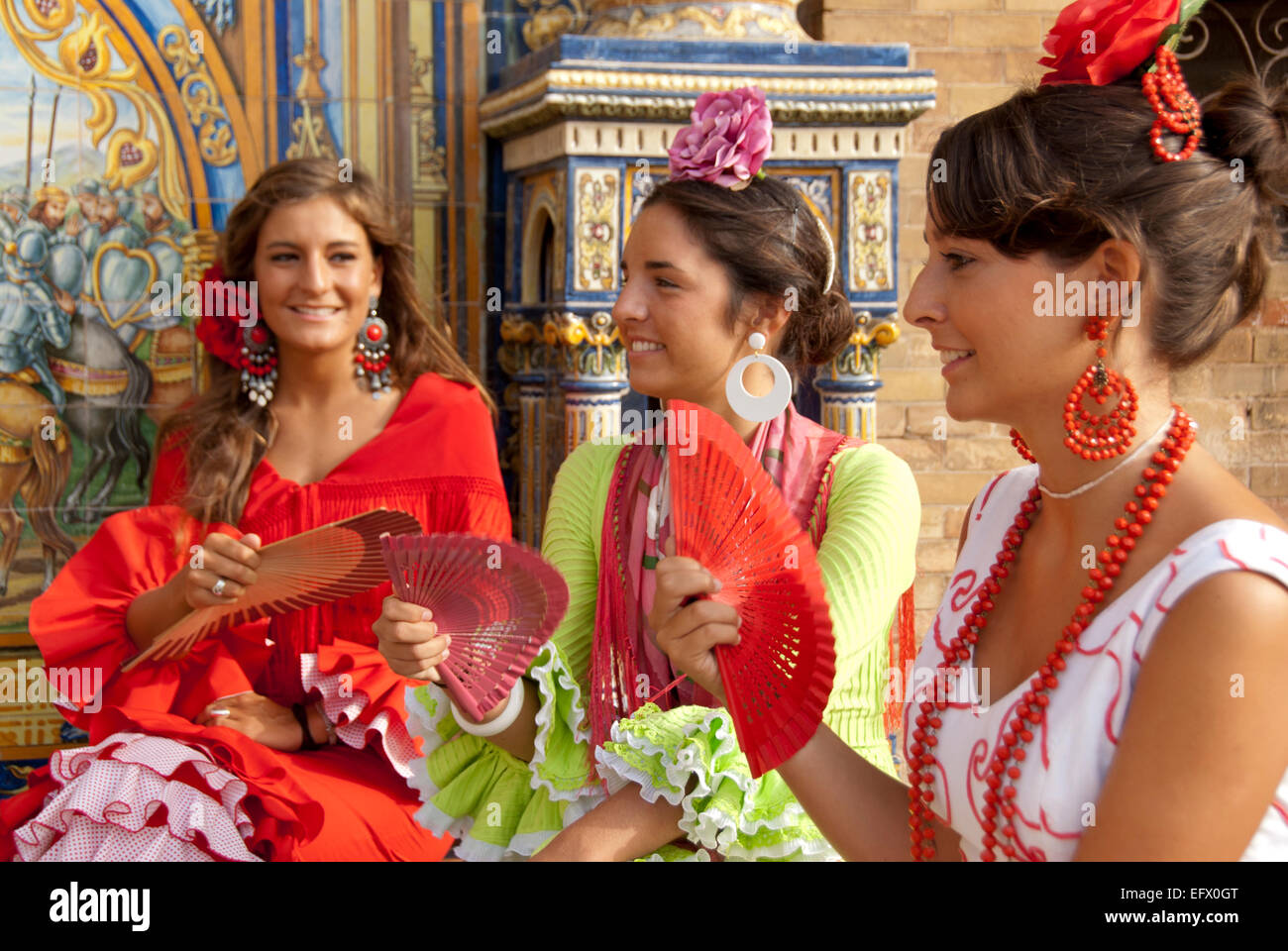 Sevilla fair Feria de Abril Sevilla Spring Fair drei Freunde im Flamenco Sevillanas Fans Trachtenmode weibliche Kleider Stockfoto
