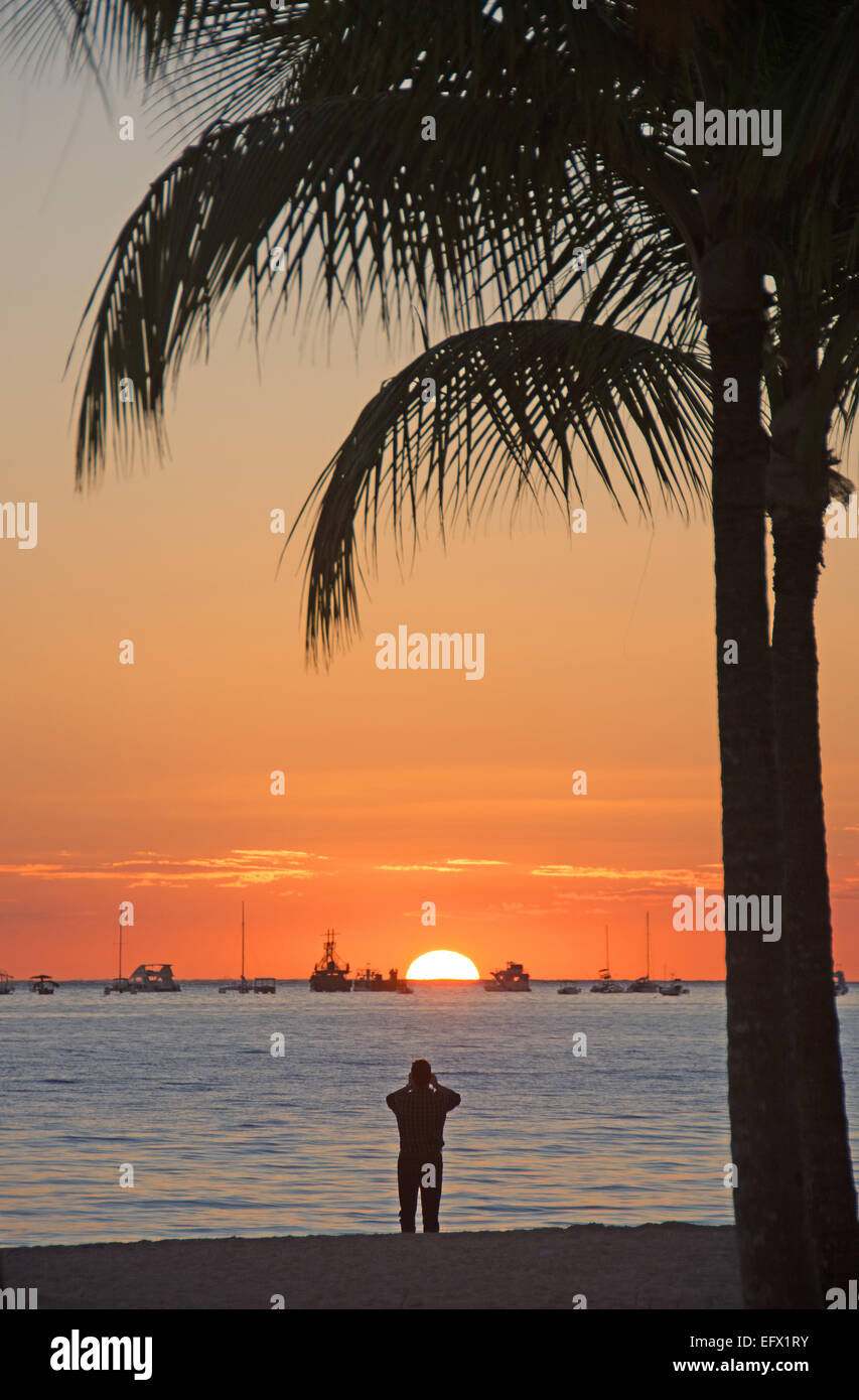Dominikanische Republik. Ein Tourist fotografiert die aufgehende Sonne am Strand von Punta Cana. 2015. Stockfoto