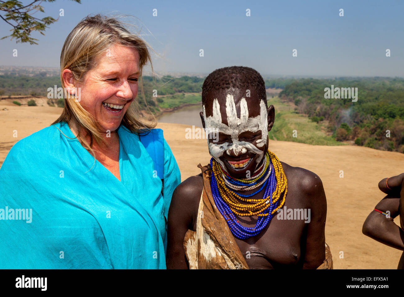 Ein Tourist posiert für ein Foto mit einer Frau vom Stamm Karo, nieder Dorf, das Omo-Tal, Äthiopien Stockfoto