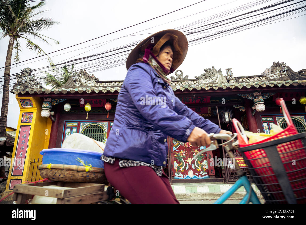 Frau mit Fahrrad durch den Quan Cong Tempel (Chua Ong), Hoi an, Vietnam. Stockfoto