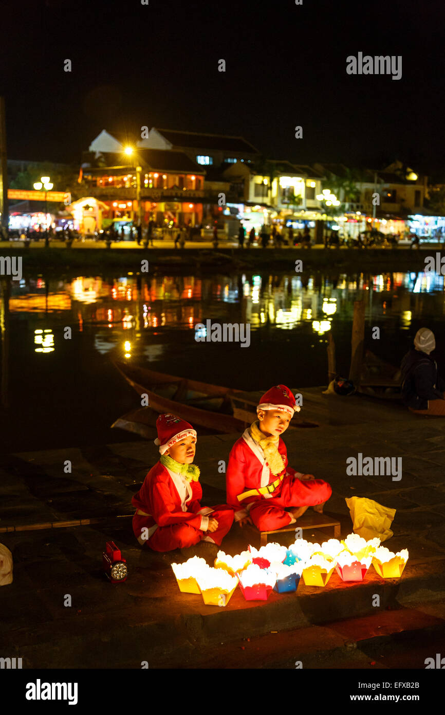 Kinder verkleidet als Weihnachtsmann, Schwimmkerzen, Hoi an, Vietnam zu verkaufen. Stockfoto