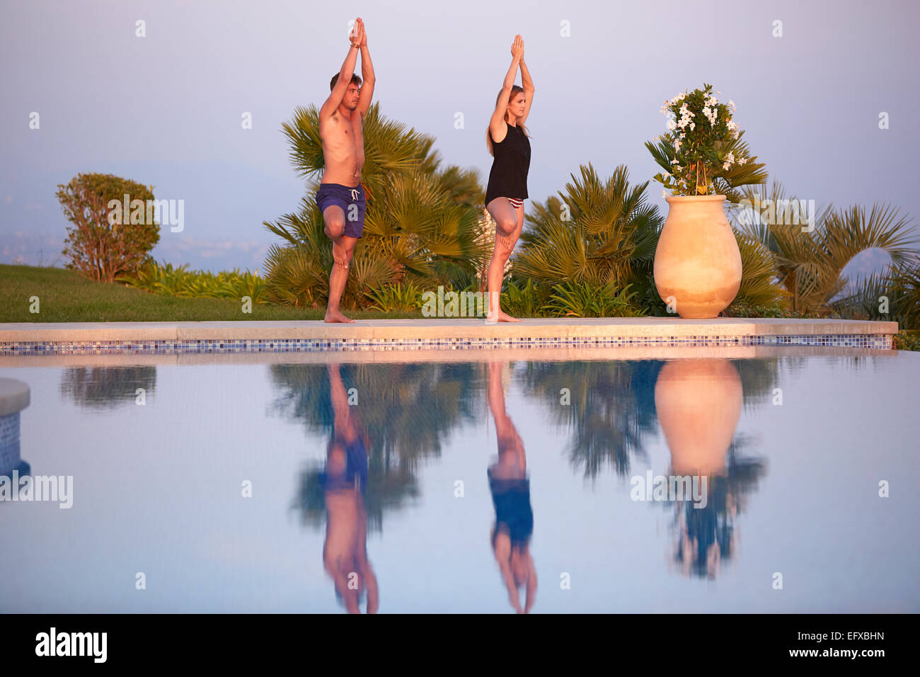 Junges Paar tun Yoga-Posen am Pool im Urlaub in Südfrankreich Stockfoto