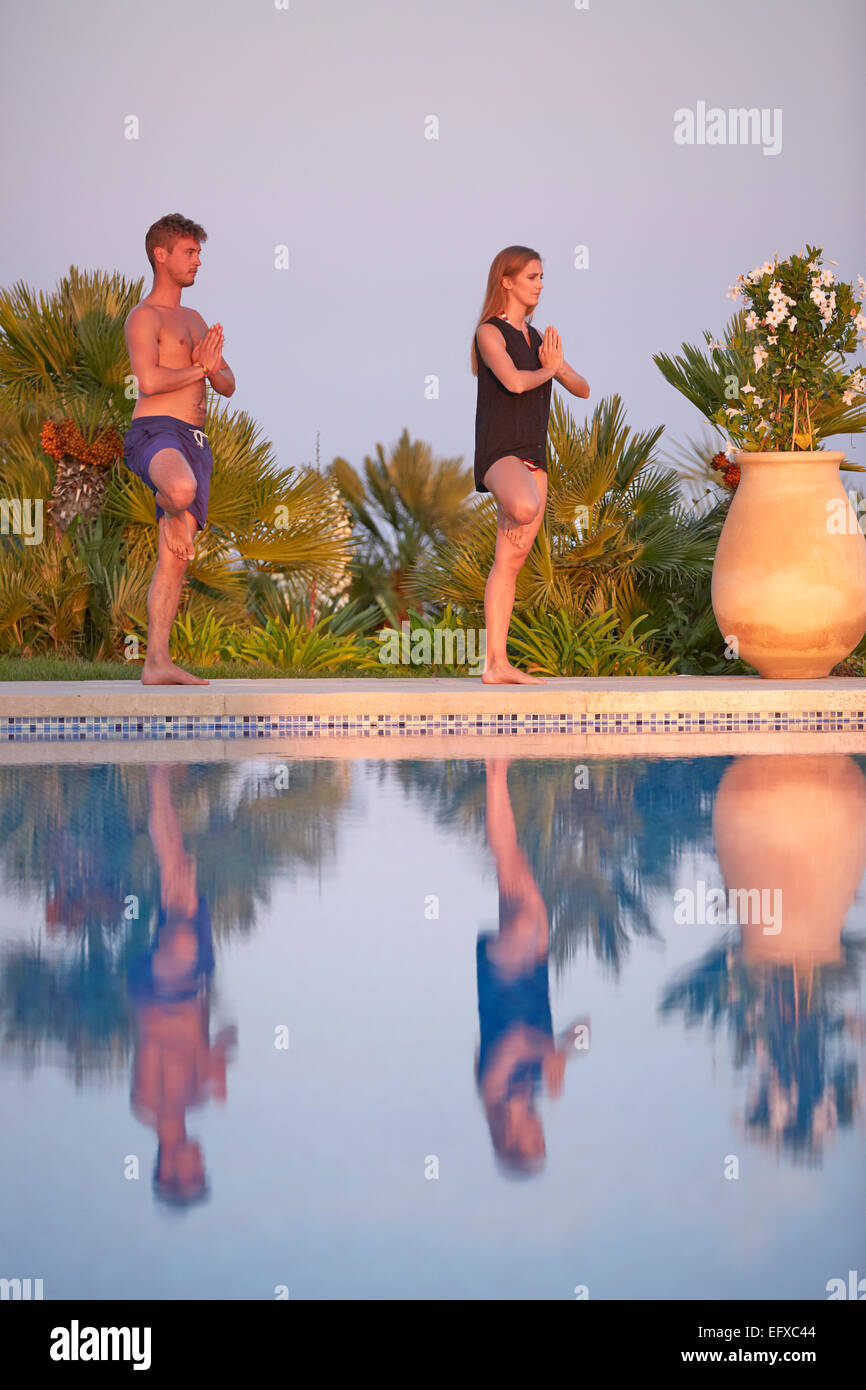 Junges Paar tun Yoga-Posen am Pool im Urlaub in Südfrankreich Stockfoto