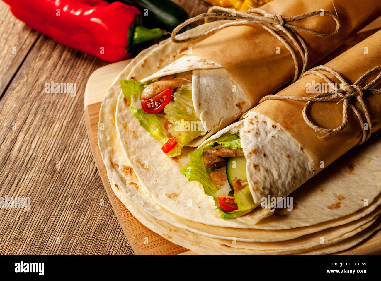 Mexikanische Tortilla wrap mit Fleisch und Gemüse auf Holztisch Stockfoto