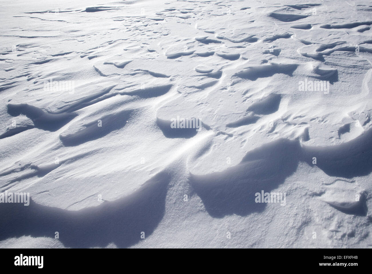 Nahaufnahme der Strukturen von Schneeverwehungen im Sonnenlicht Stockfoto