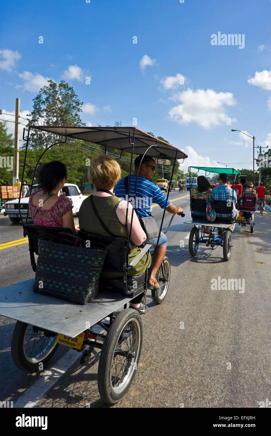 Vertikale Ansicht des Bicitaxis hinunter eine Hauptstraße in Camagüey, Kuba. Stockfoto