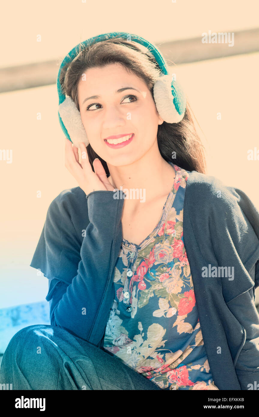 junge schöne Brünette Frau Mädchen hören Musik Kopfhörer im freien Stockfoto