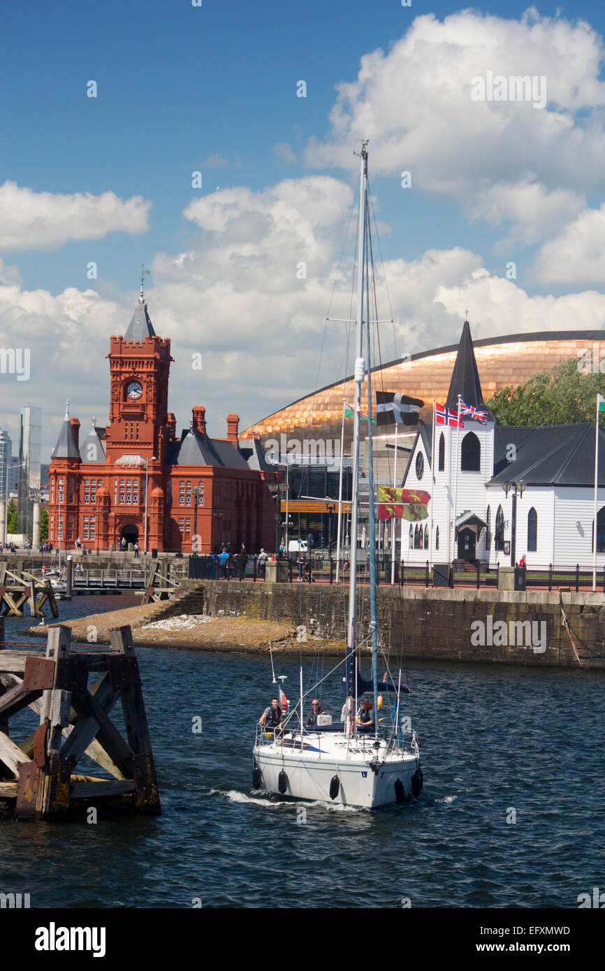 Cardiff Bay norwegische Kirche, Millennium Centre und Pierhead Gebäude mit Boot Segeln im Hafen von Cardiff Wales UK Stockfoto