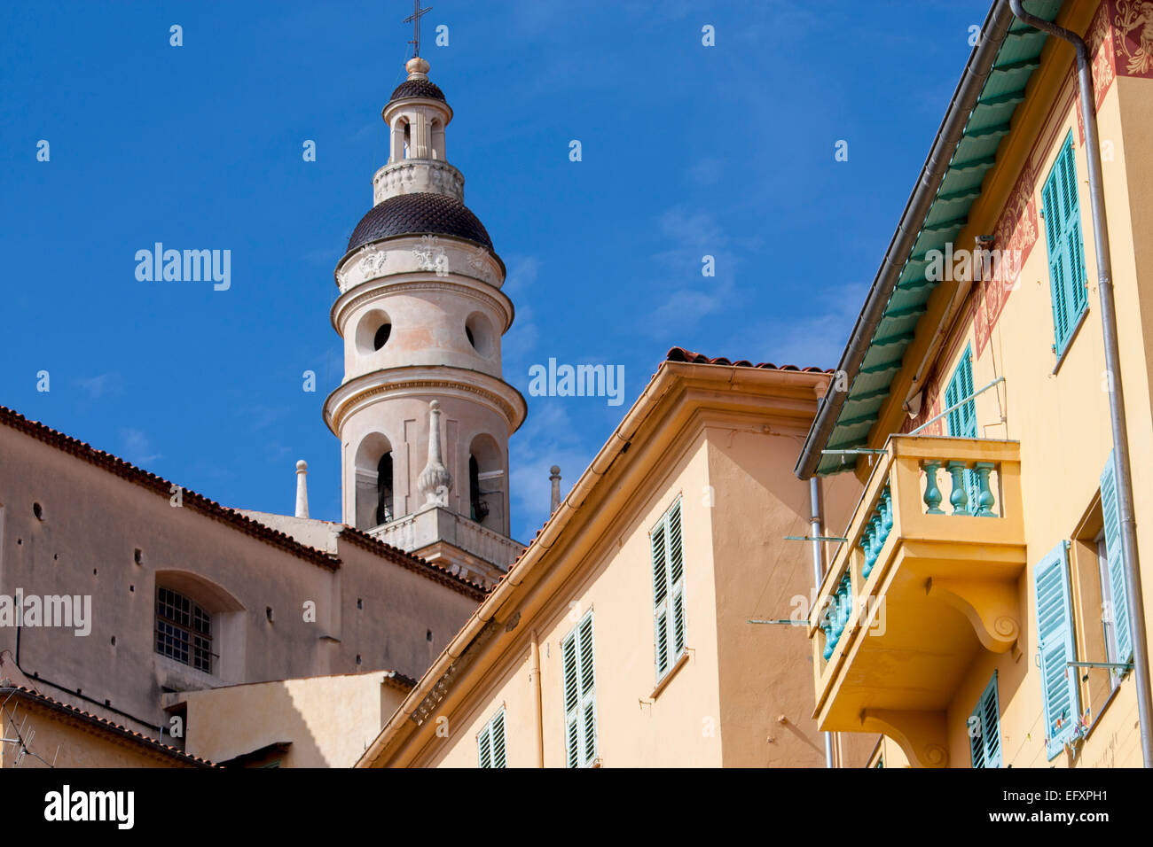 Menton St Michel Kirchturm mit Pfirsich farbigen Haus mit leichten blauen Fensterläden im Vordergrund im Vordergrund Alpes-Maritimes Kinderbett Stockfoto