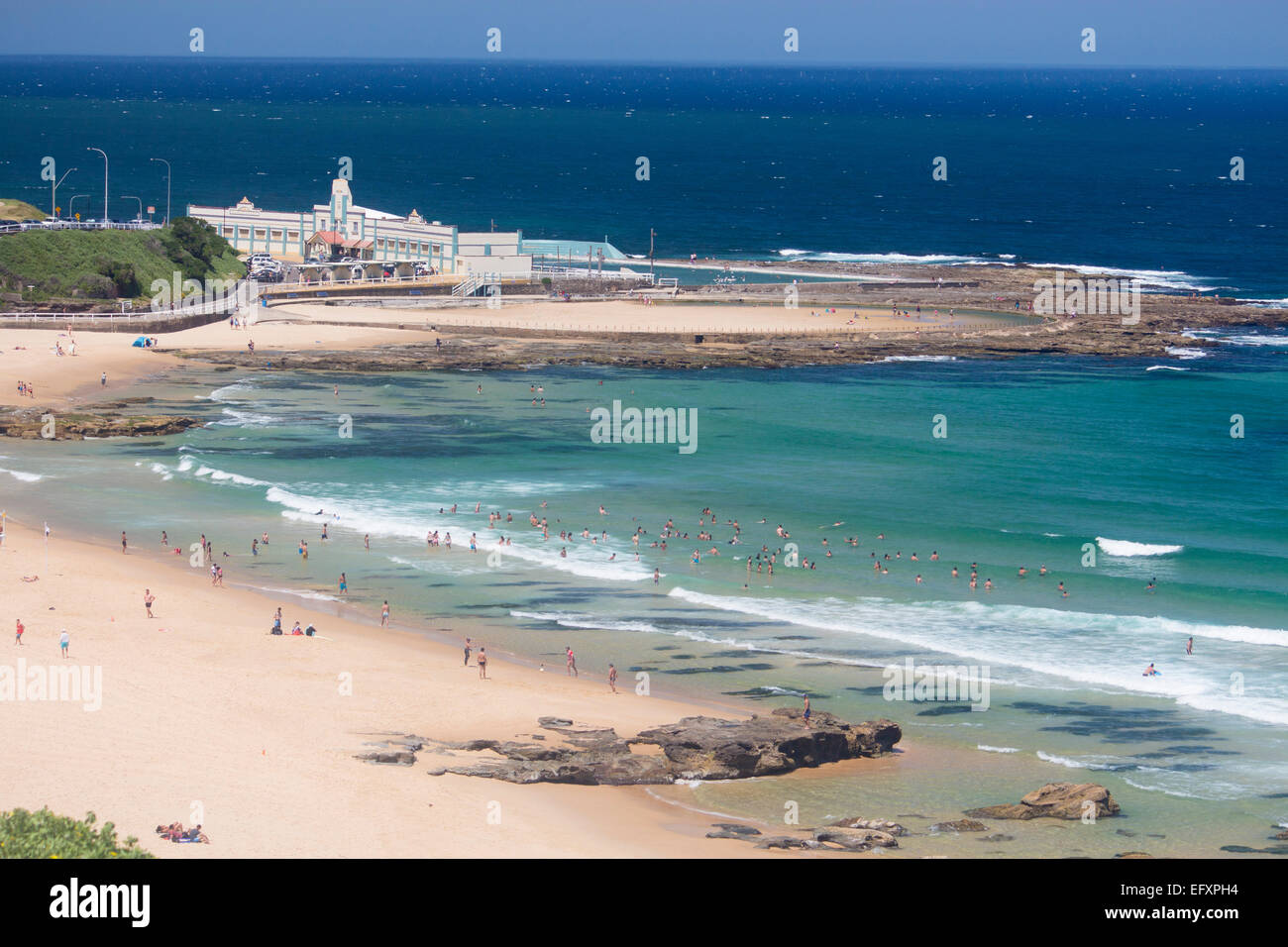 Newcastle Beach im Sommer mit Menschen und Meer Bäder in Ferne Newcastle NSW New South Wales Australien Stockfoto