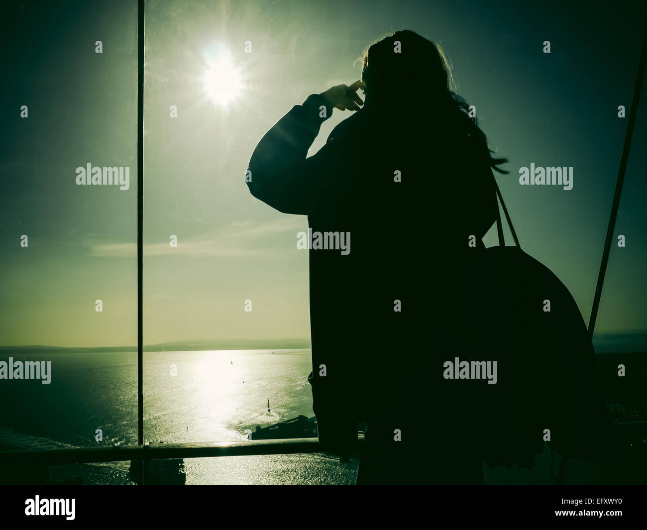 Eine junge Frau schaut über den Solent aus Ansicht Deck im Inneren des Spinnaker Tower, Portsmouth, England Stockfoto