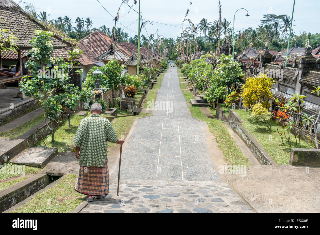 Ein Alter Mann geht durch die Gasse auf der Community-Based Tourism Village Penglipuran (Desa Wistata Penglipuran Berbasis Masyarakat) Stockfoto