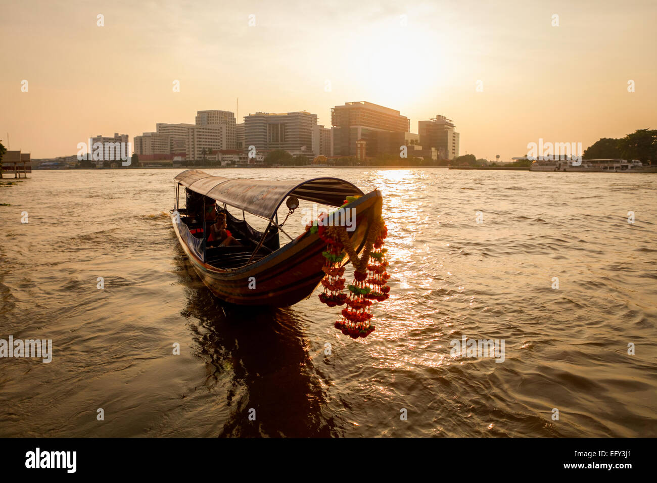 Langes Boot mit Blumendekoration für den Tourismus auf dem Chao Phraya Fluss in Bangkok, Thailand. Stockfoto