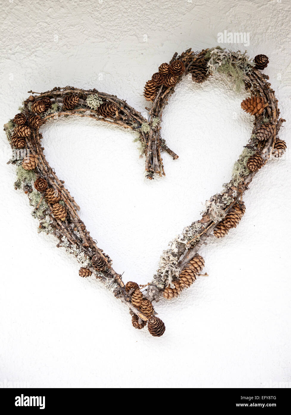 Herzförmige Kranz gemacht von Zweigen, Flechten und Zapfen Stockfoto