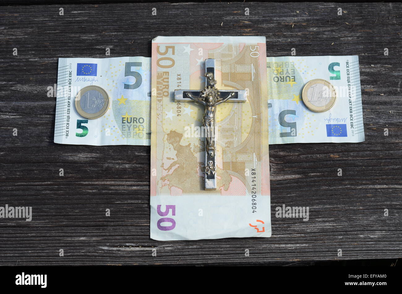 Euro Geld Kreuz und Metall Kreuzigung Jesus Konzept Stockfoto