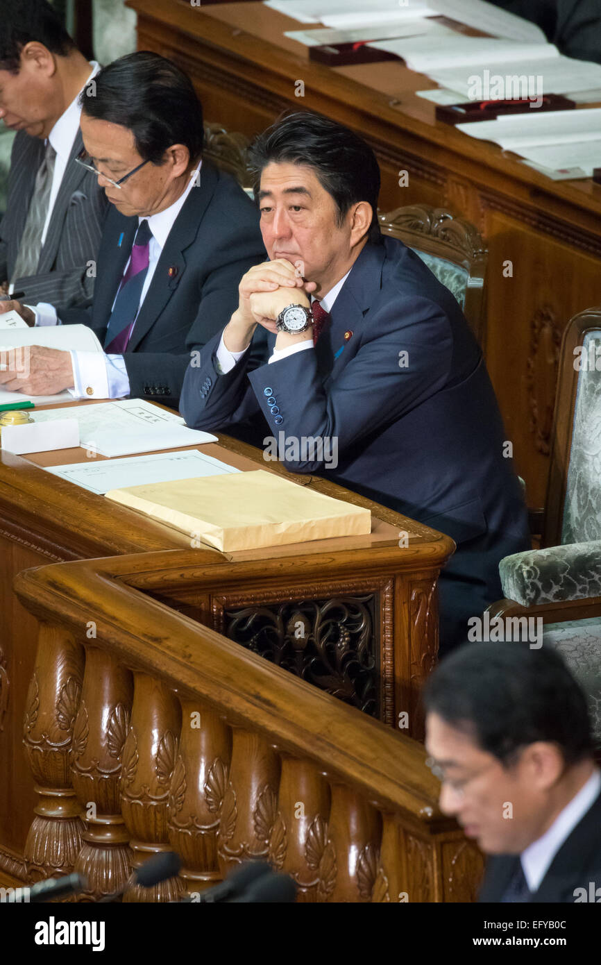 Tokio, Japan. 12. Februar 2014. Japans Ministerpräsident Shinzo Abe ruht sein Kinn in seine Hände wie hört er Außenminister Fumio Kishida, Vordergrund, liefert seine außenpolitische Rede während einer Plenarsitzung der beiden Häuser des Reichstages in Tokio auf Donnerstag, 12. Februar 2015. Bildnachweis: AFLO/Alamy Live-Nachrichten Stockfoto