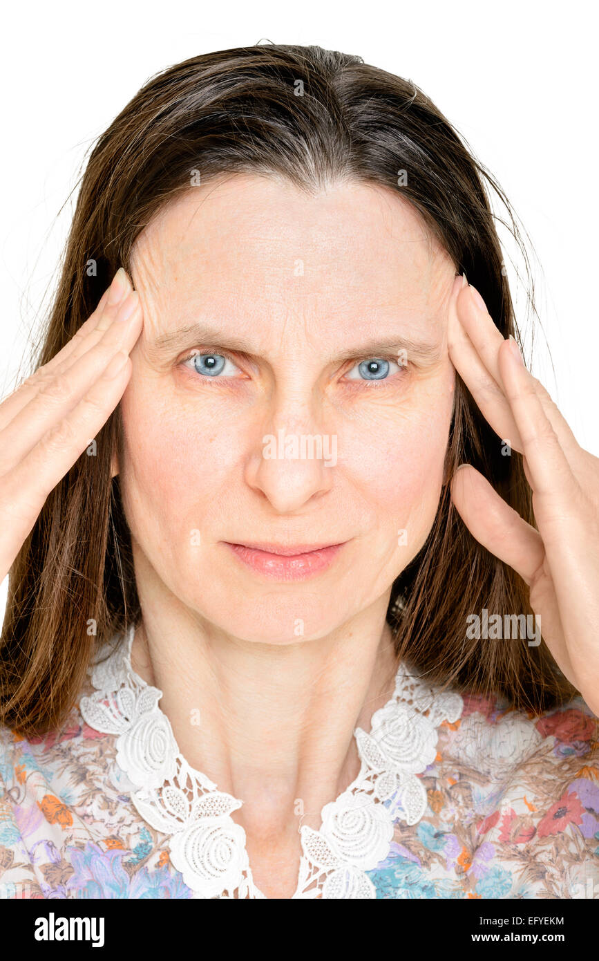 Eine erwachsene Frau legt ihre Finger an den Schläfen, weil sie von Kopfschmerzen leidet Stockfoto