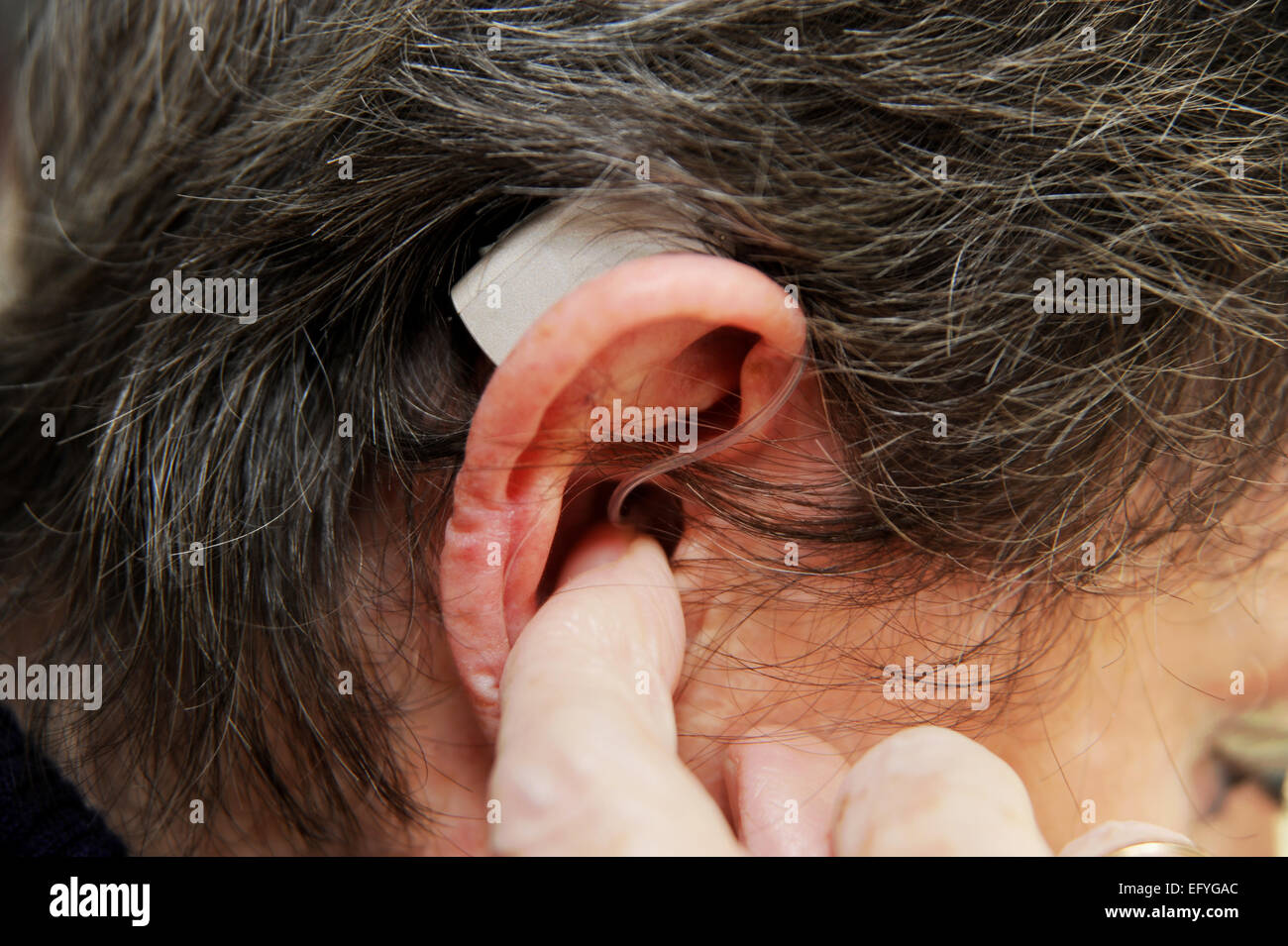 Ältere Dame Frau weiblich Hörgerät in ihren Ohren schwerhörig zu tragen Stockfoto