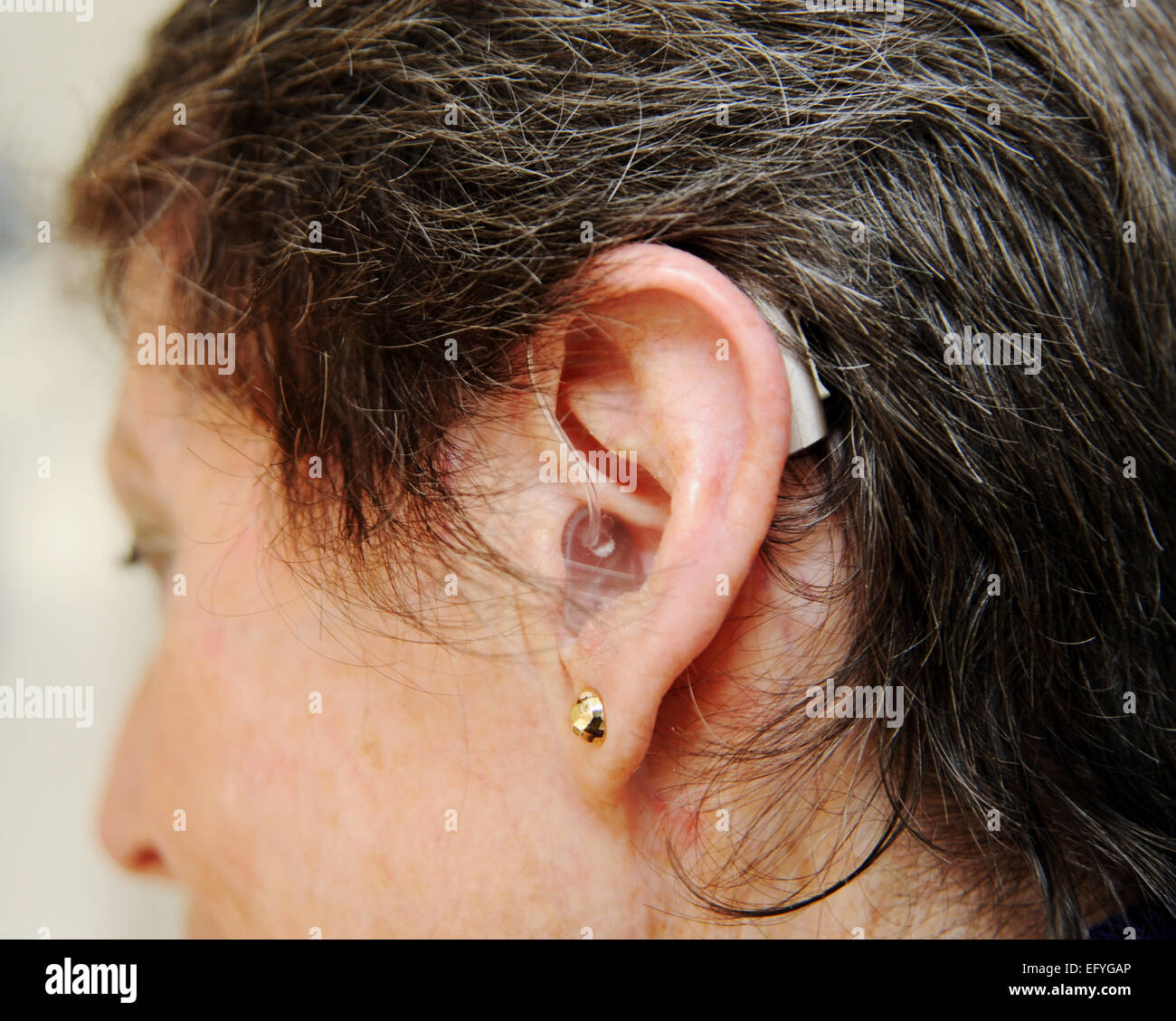 Ältere Dame Frau weiblich Hörgerät in ihren Ohren zu tragen, wie sie ist schwerhörig Stockfoto