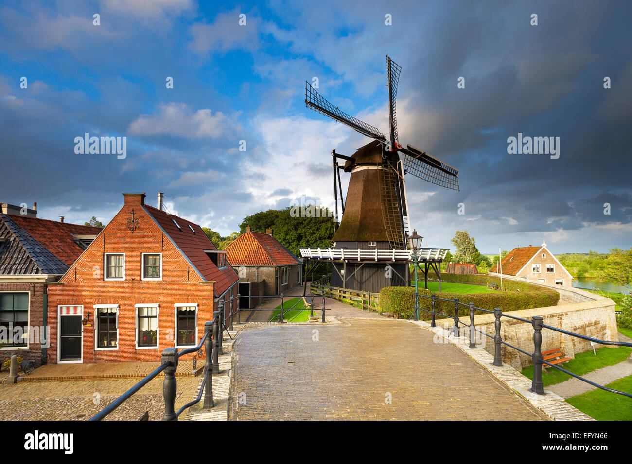 Eine typisch holländische Stadt in den Niederlanden mit alten Häusern und einer Windmühle und einer Brücke über den Kanal Stockfoto