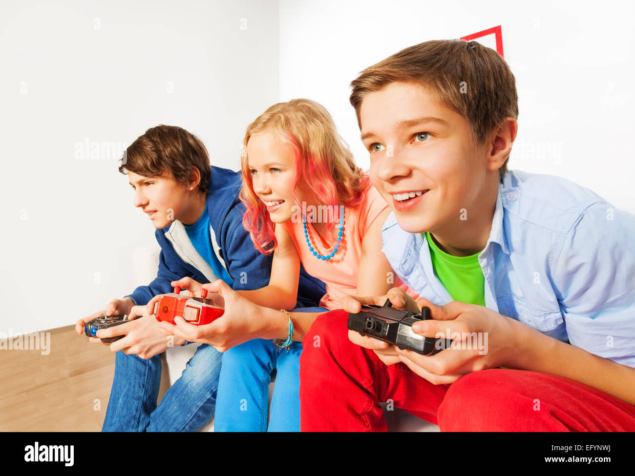 Drei Freunde mit Joysticks spielen Spiel-Konsole Stockfoto