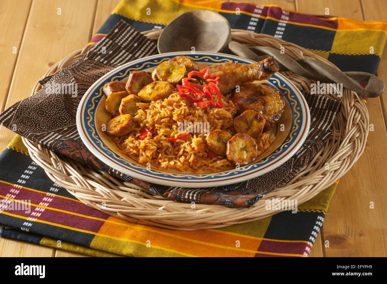 Jollof Reis mit gebratenem Huhn und Wegerich. Stockfoto