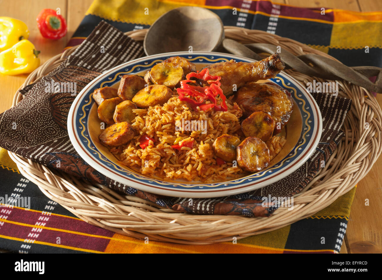 Jollof Reis mit gebratenem Huhn und Wegerich. Stockfoto