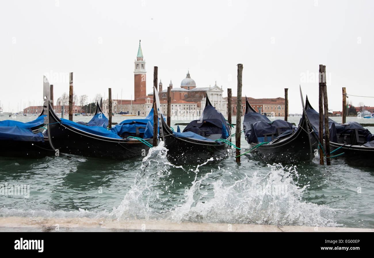 Hohe Wasser, acqua alta, Überschwemmungen viele Teile von Venedig, Venetien, Italien. Gondeln günstig entlang der Riva degli Schiavoni Waterfront, mit der Insel San Giorgio Maggiore im Hintergrund. Stockfoto