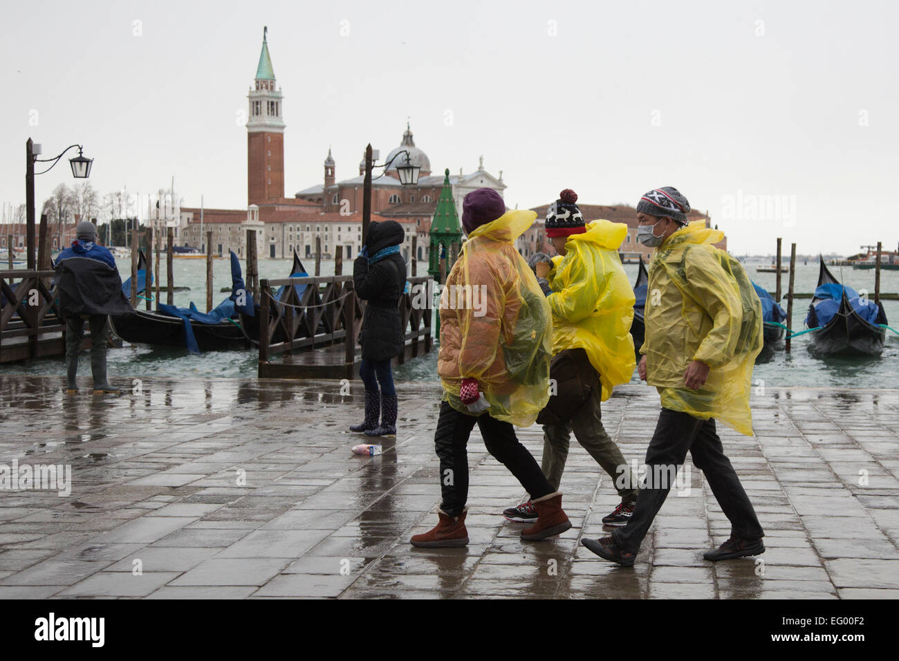 Als der jährliche Karneval feiern losgehen, in Venedig, Hochwasser (Acqua Alta) viele Teile der Stadt überflutet. Viele Touristen wurden von den hohen Wassergehalt ertappt und musste kaufen verstärkten Kunststoff Stiefel in leuchtenden Farben - die über normale Schuhe - getragen werden, trocken zu halten. Besseres Wetter für den Karneval in Markusplatz entfernt dieses Wochenende prognostiziert. Stockfoto
