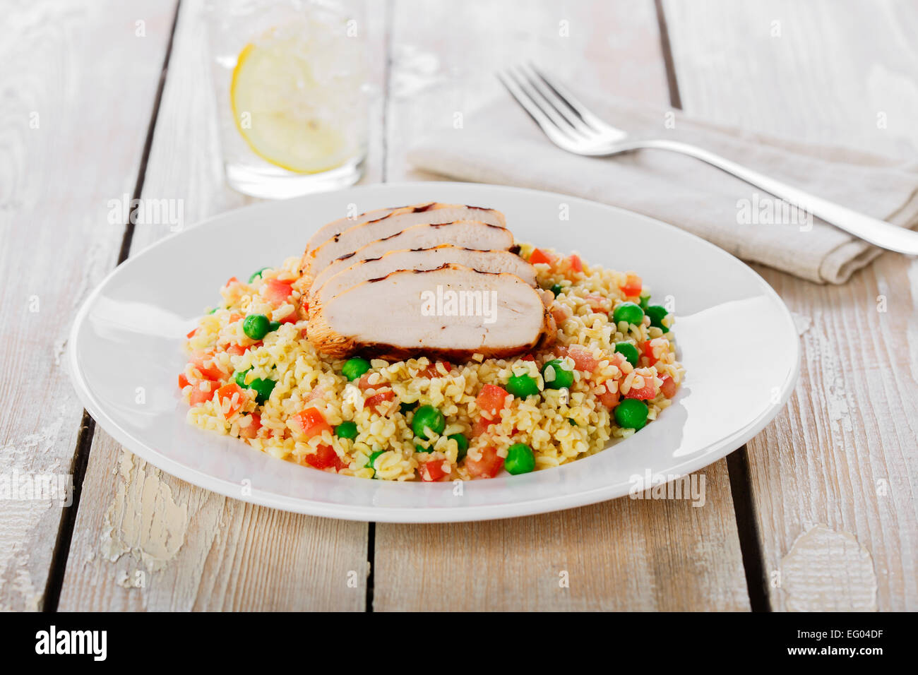 Couscous mit grünen Erbsen und Filet Hähnchengrill Stockfoto