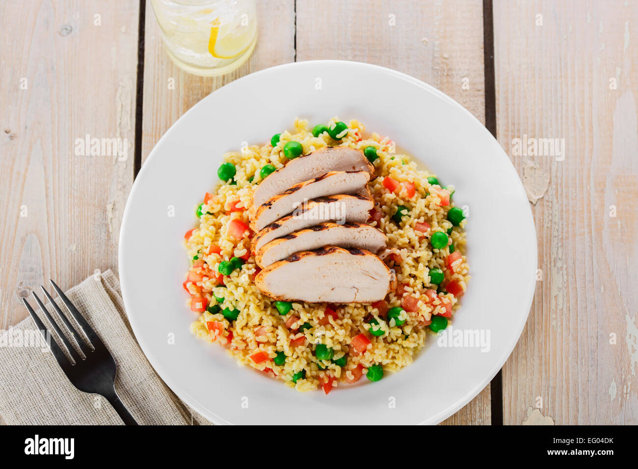 Couscous mit grünen Erbsen und Filet Hähnchengrill Stockfoto