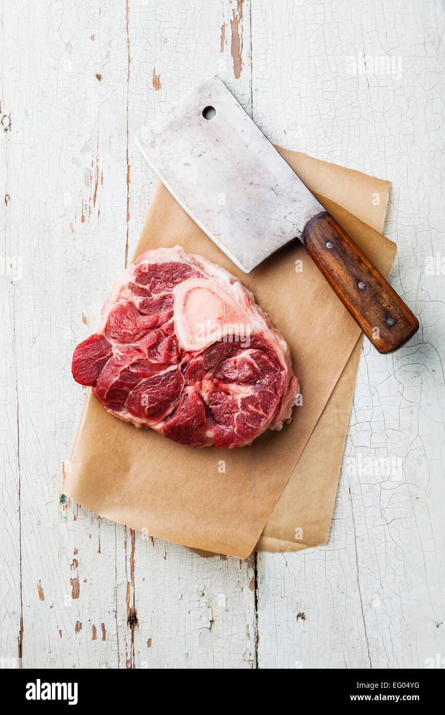 Roh frisch Kreuz geschnittene Kalbfleisch Schaft und Fleisch-Hackmesser für die Herstellung von Osso Buco auf blauem Hintergrund Stockfoto