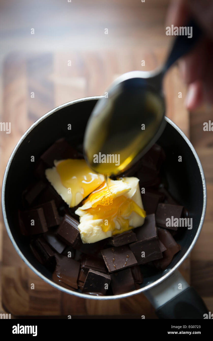 Backen mit geschmolzener Schokolade Sauce in einem Topf. Stockfoto