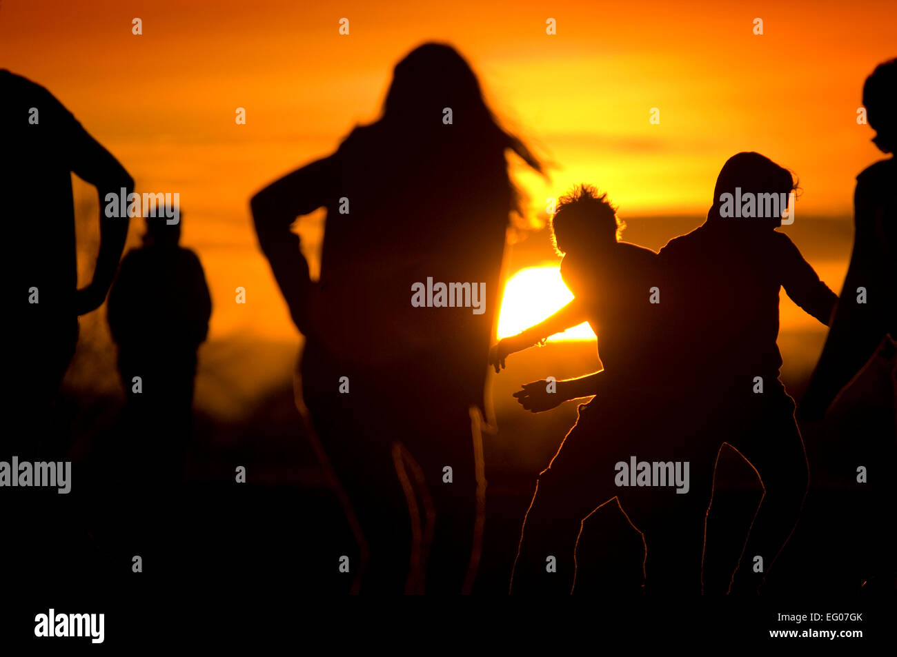 Junge Menschen spielen bei Sonnenuntergang auf Durdham Downs in Bristol. Stockfoto