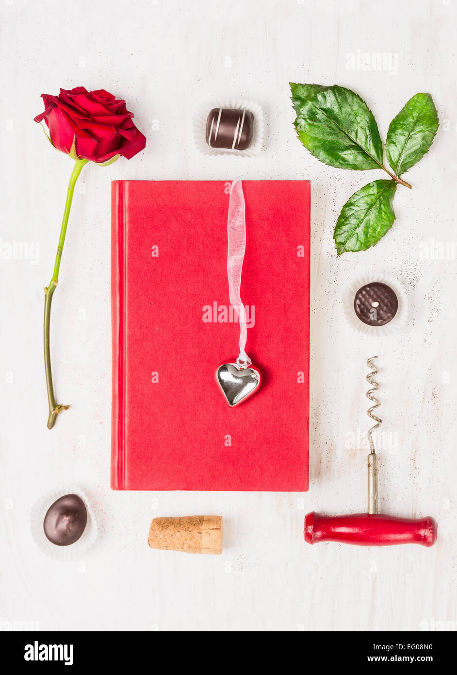 Liebesgeschichte komponieren mit Buch, Herz, rot, rose, Schokolade und Korkenzieher auf weißem Hintergrund, Ansicht von oben Stockfoto