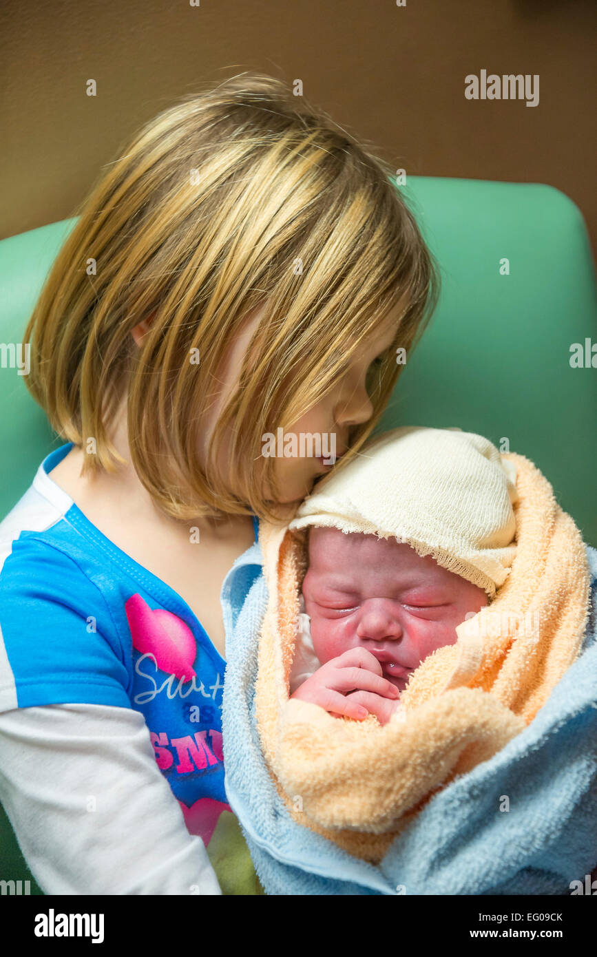 Junges Mädchen hält und neue Baby Bruder Küsse Stockfoto