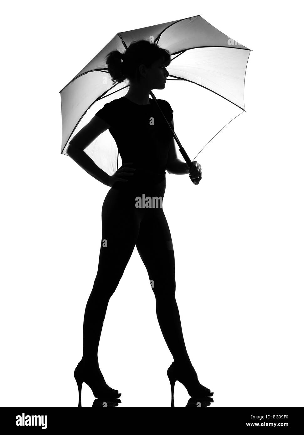 voller Länge Silhouette im Schatten einer jungen Frau stehend mit offenen Regenschirm im Studio auf weißen Hintergrund isoliert Stockfoto