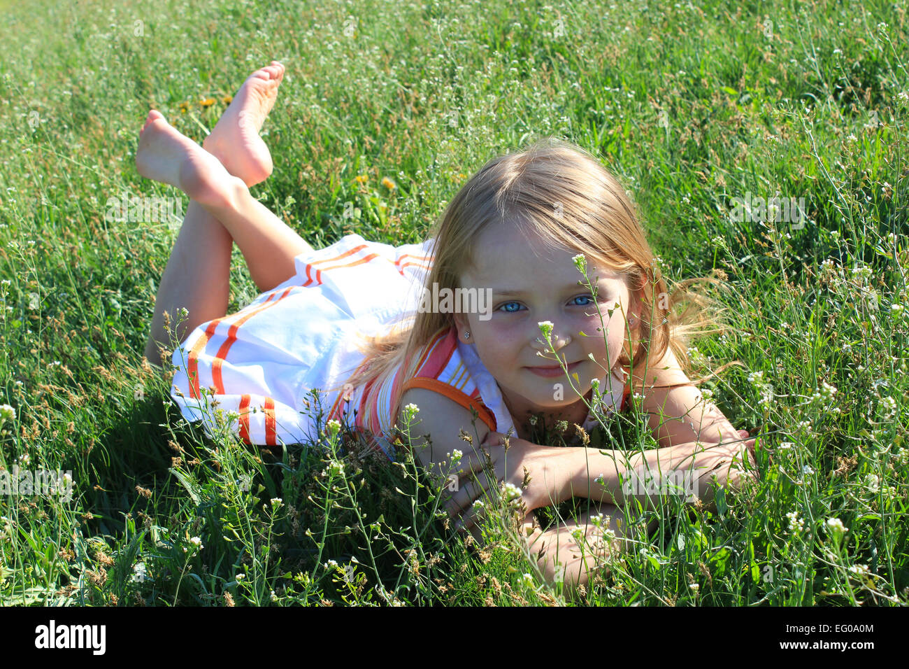 modische Mädchen liegend auf dem grünen Rasen Stockfoto