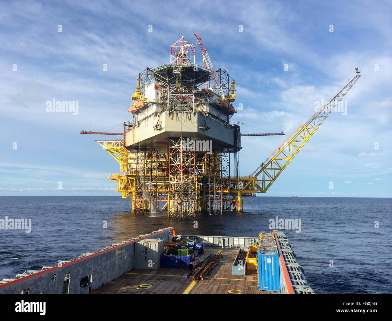 Seeschiff nähert sich einer Ölplattform Stockfoto