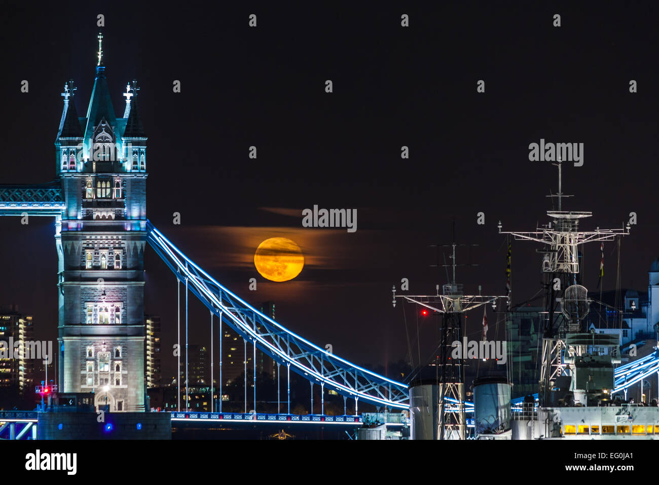 Großbritannien, London, beleuchtete Tower Bridge, Schiff am Fluss und voller gelber Mond im schwarzen Himmel Stockfoto