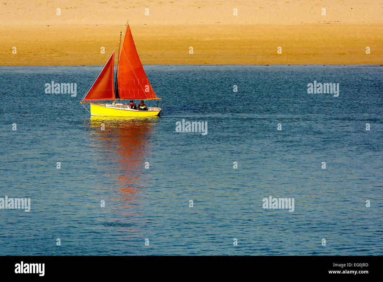 United Kingdom, England, Padstow, Segelboot mit roten Segeln Strand Stockfoto