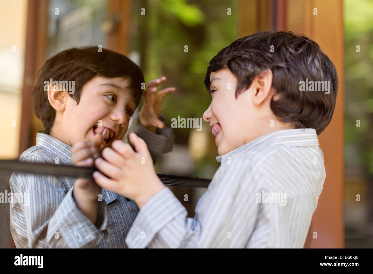 Jungen (4-5) ziehende Gesicht gegen Spiegel Fenster Stockfoto