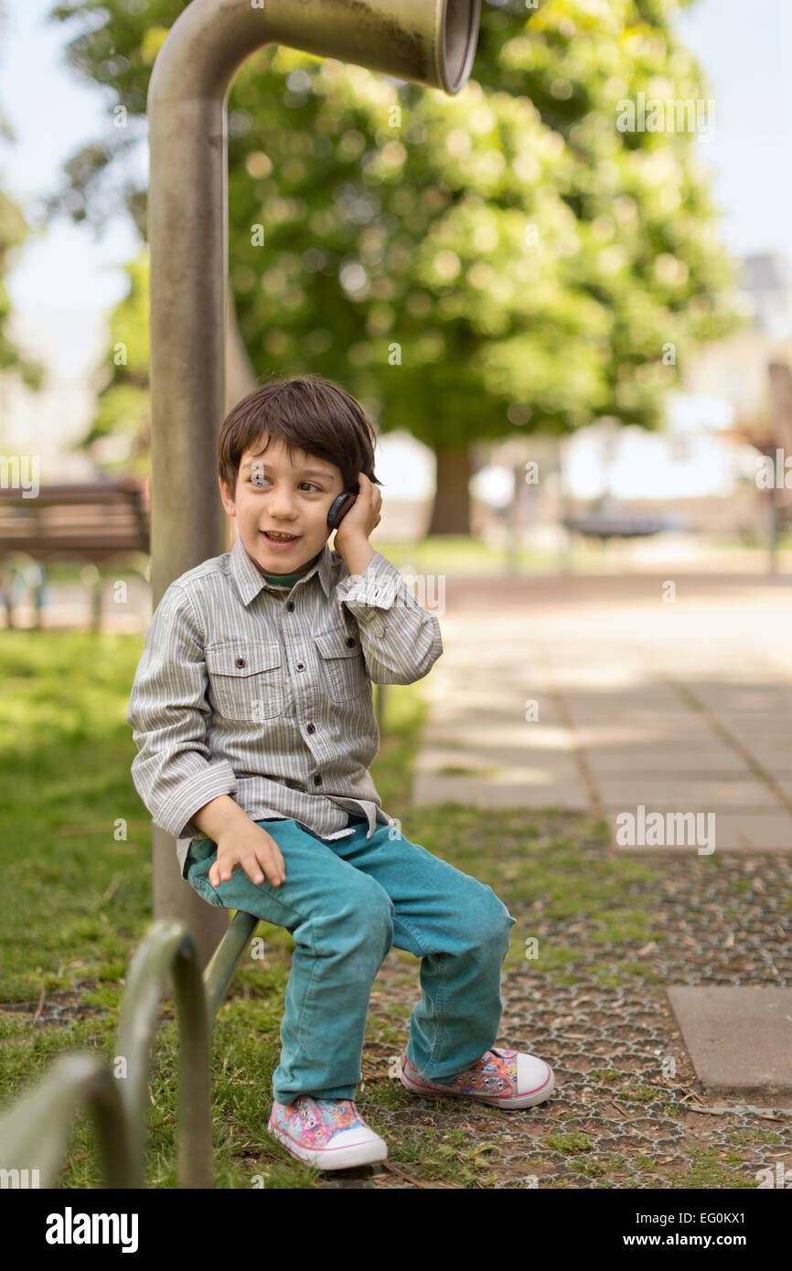 Bulgarien, Sofia, junge (4-5) sitzt auf Park Geländer telefonieren mit Handy Stockfoto