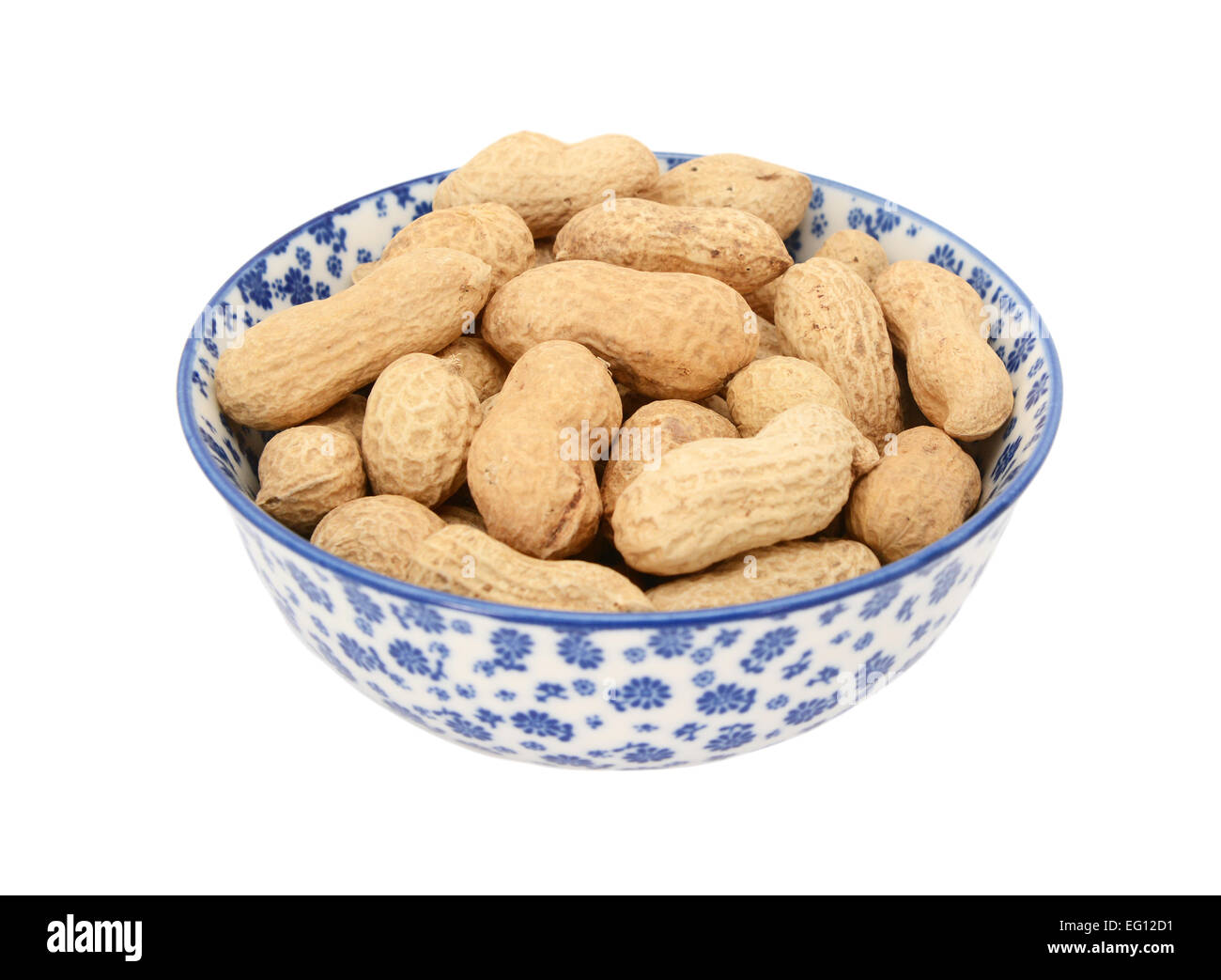Monkey Nuts in einer blau-weißen Porzellanschüssel mit floralem Design, isoliert auf weißem Hintergrund Stockfoto